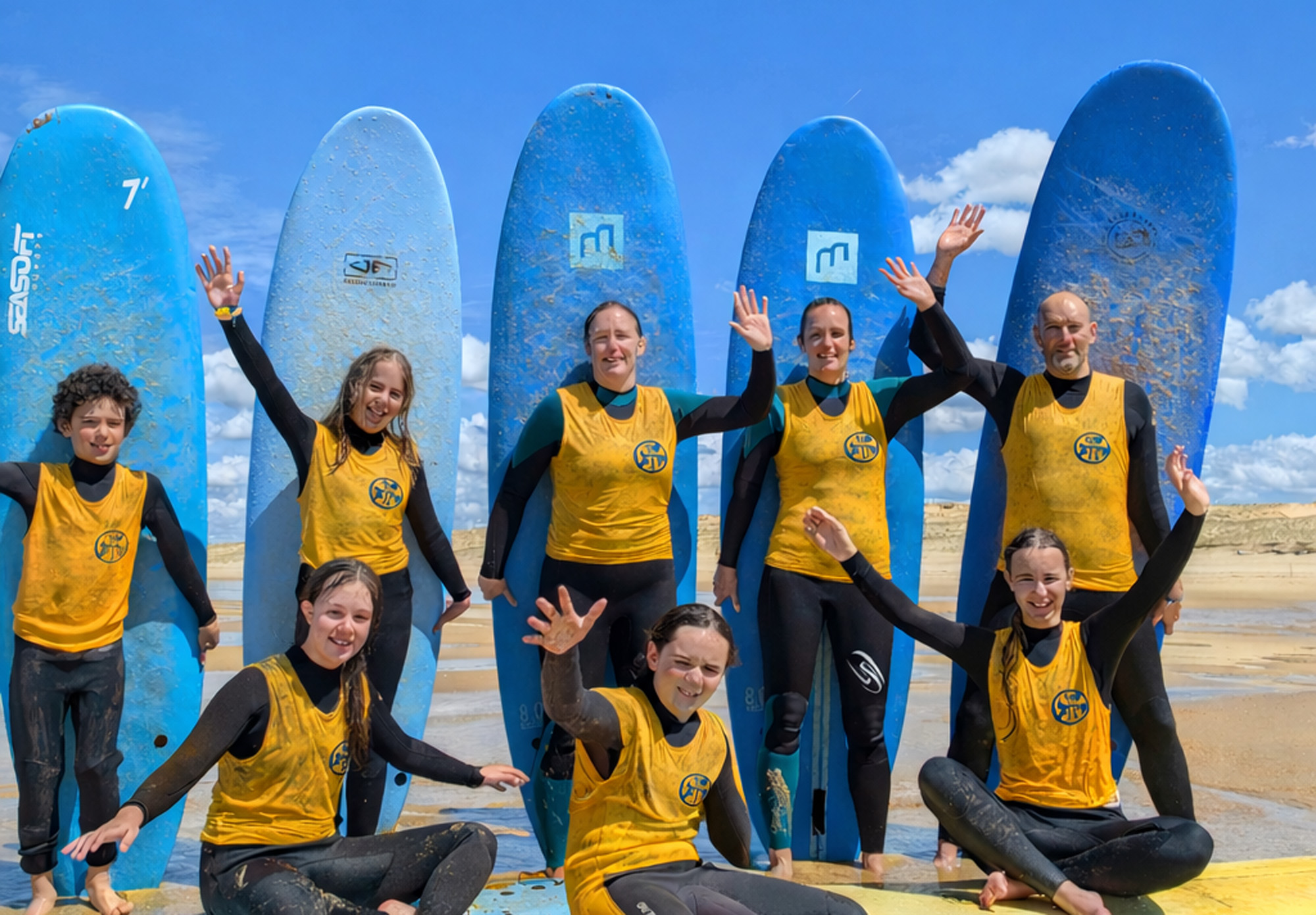 Groupe de surfeurs souriants tenant leurs planches de surf
