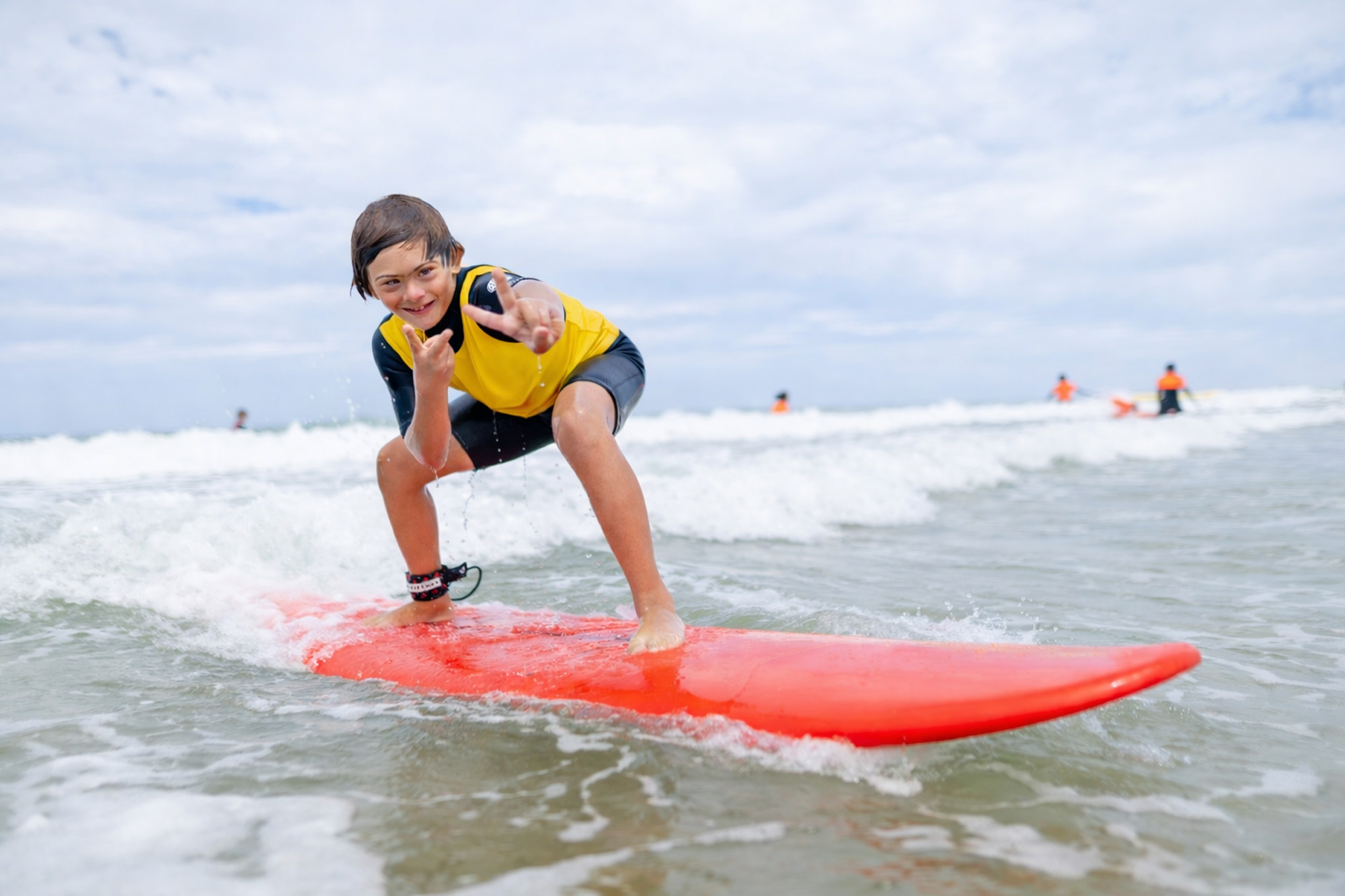 Jeune surfeur handicapé souriant pendant une session de surf