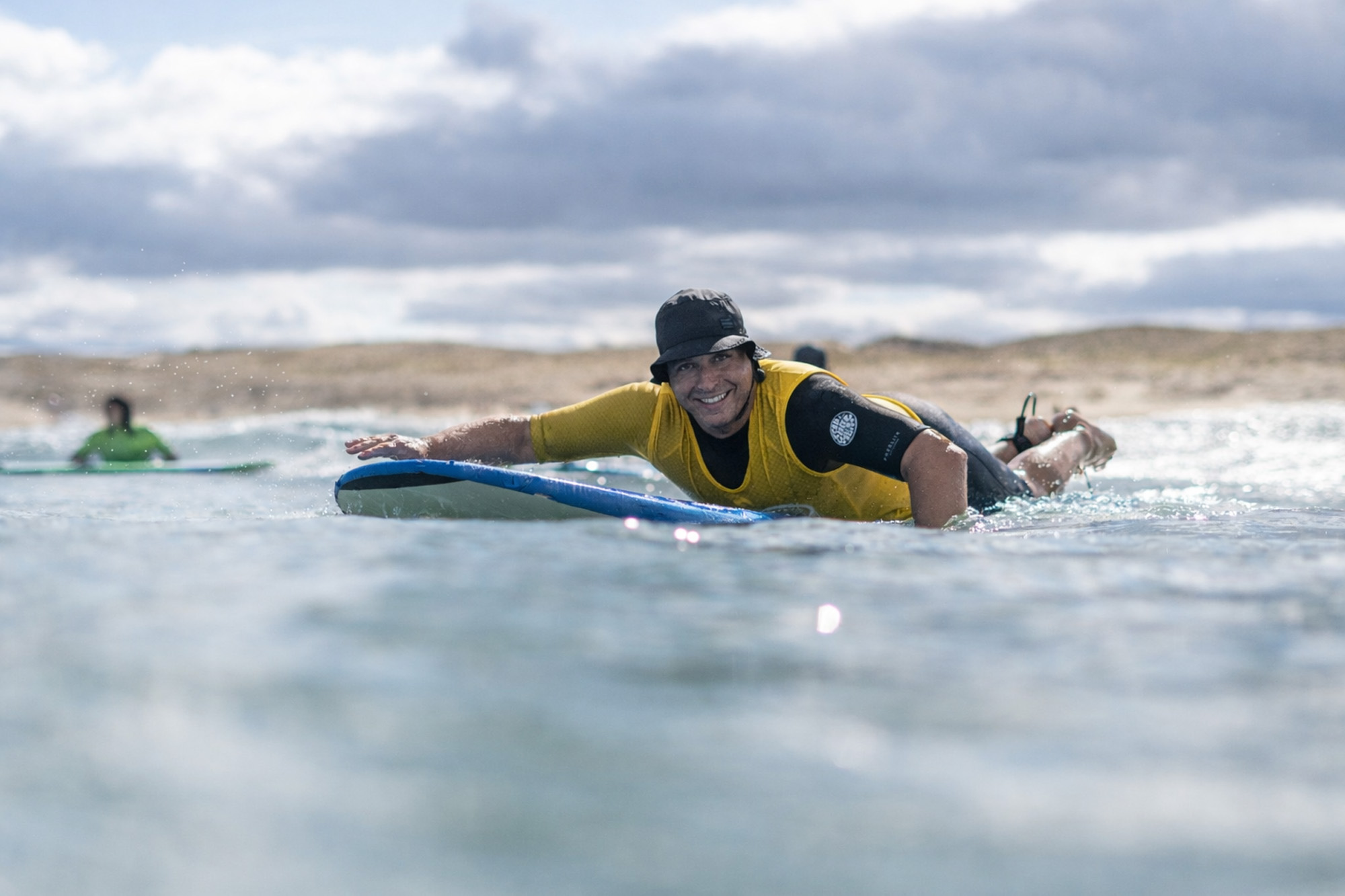Participant accompagné dans l’eau lors d’une séance de Surf Santé