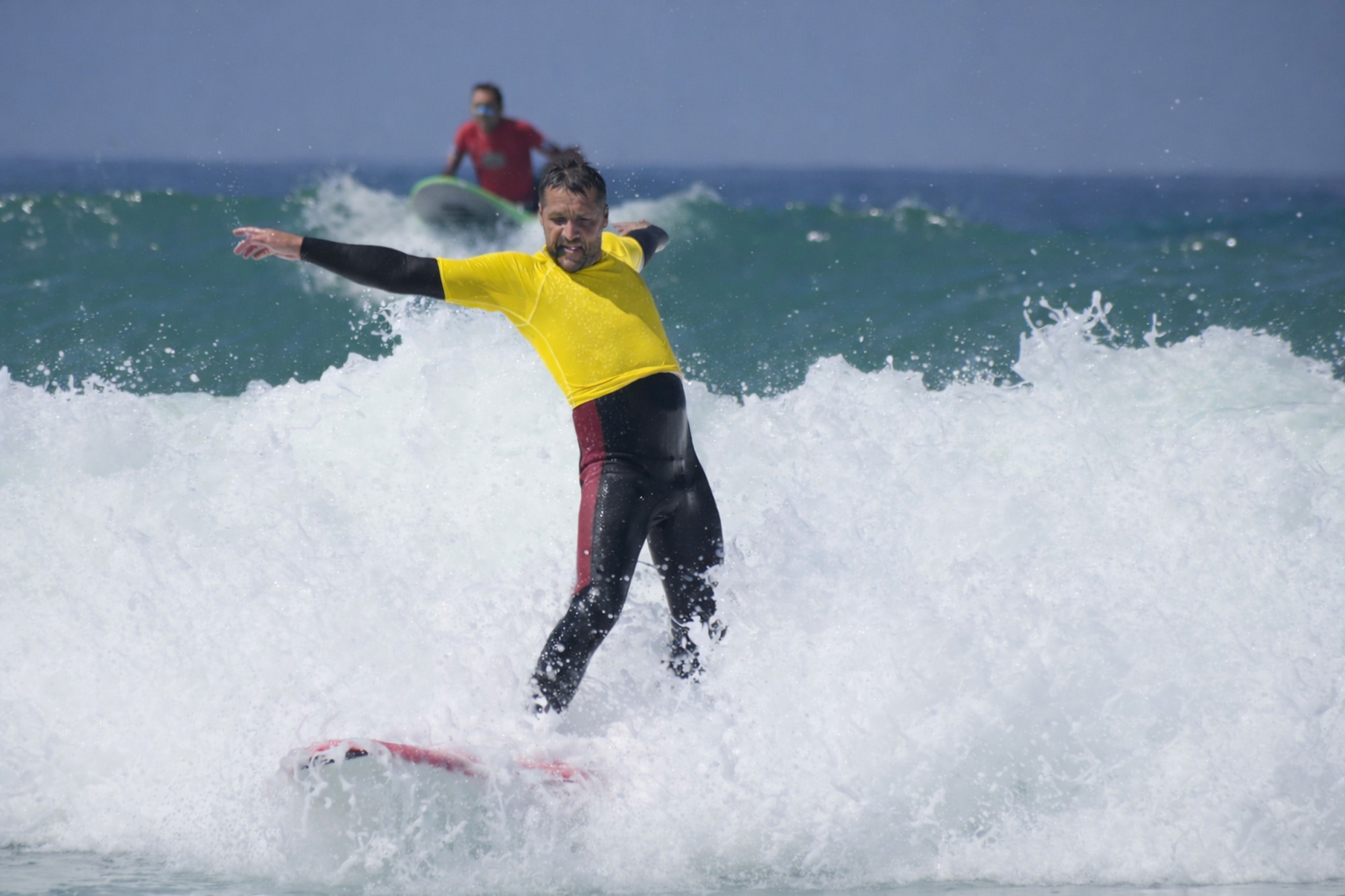 Surfeur adulte en combinaison évoluant sur une vague