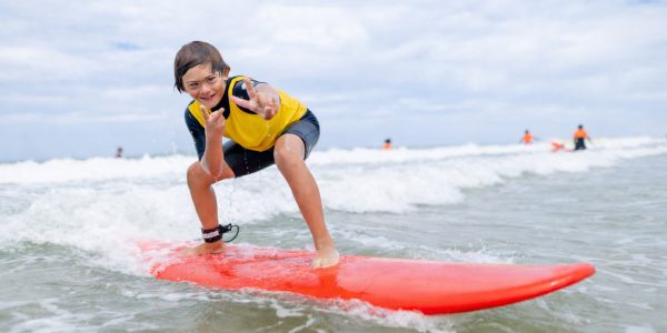 Jeune surfeur handicapé souriant pendant une session de surf