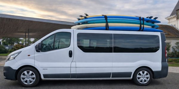 Minibus de transport avec planches de surf sur le toit