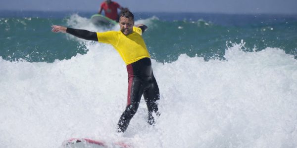 Surfeur adulte en combinaison évoluant sur une vague